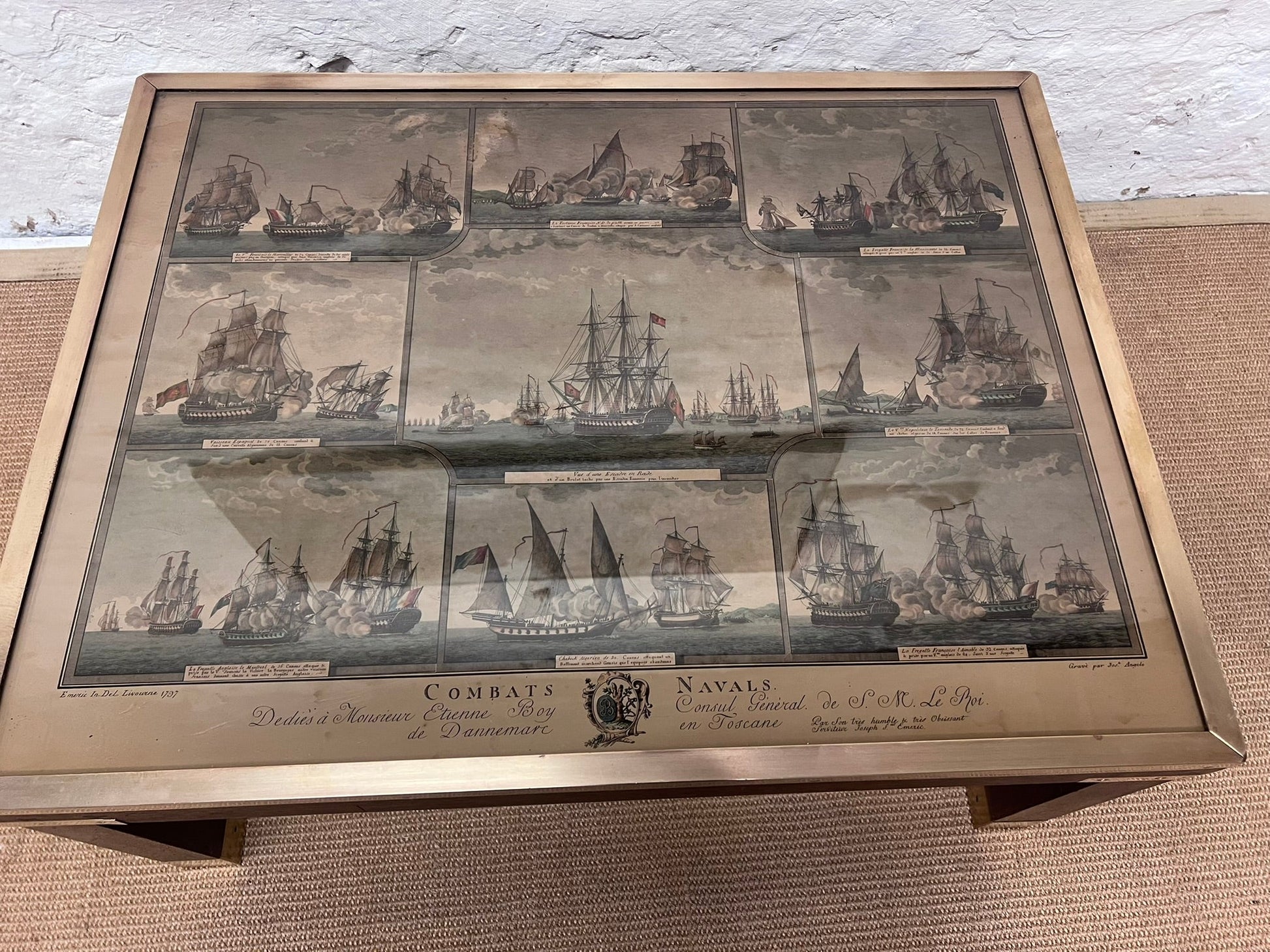 Framed artwork depicting naval battles with ships on a textured surface.
