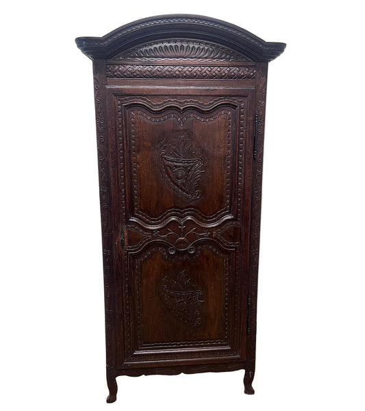 Decorative wooden cabinet against a textured white wall.