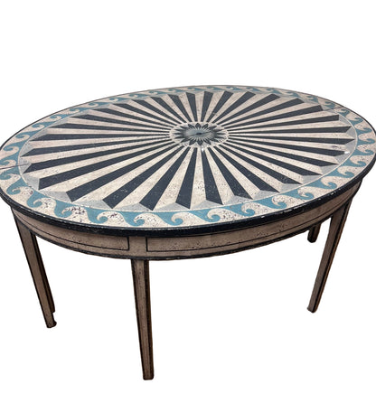 Round table with decorative sunburst pattern on a textured wall background